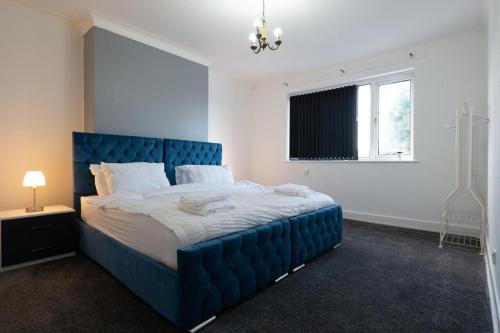 a blue bed in a white room with a window at 2-bedroom- Stoke-on-Trent-Sleeps 5-PetsOk in Stoke on Trent
