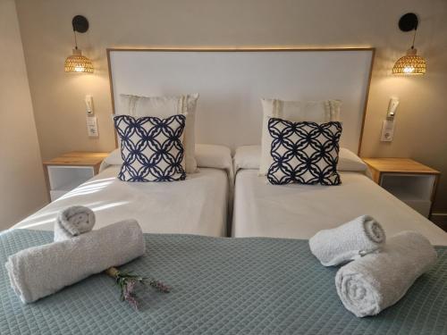 a hotel room with two beds with towels on them at Hotel Bodegón de Peñíscola in Peñíscola