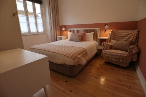 a bedroom with a bed and a chair at Giraffe House in Lisbon