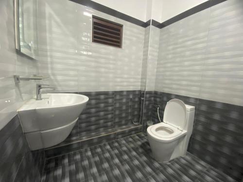 a bathroom with a white toilet and a sink at Blue Harbour Inn in Trincomalee