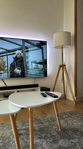 un salon avec une télévision et une table dans l'établissement Appartement, à Agde