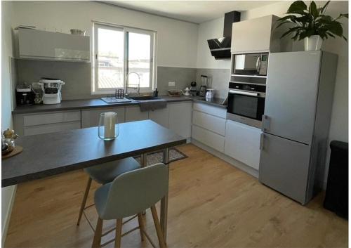 une cuisine avec une table et un réfrigérateur dans l'établissement Appartement, à Agde