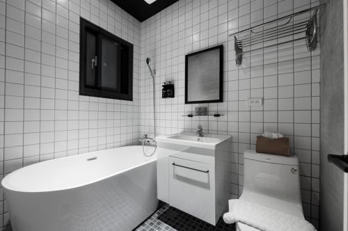 a bathroom with a tub and a toilet and a sink at 鄉都文旅 in Jiaoxi