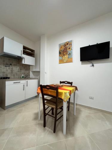 a kitchen and dining room with a table and a television at Masseria Causio in Giurdignano