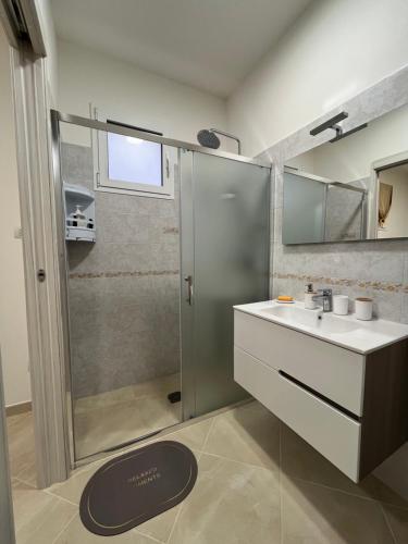 a bathroom with a shower and a sink and a mirror at Masseria Causio in Giurdignano