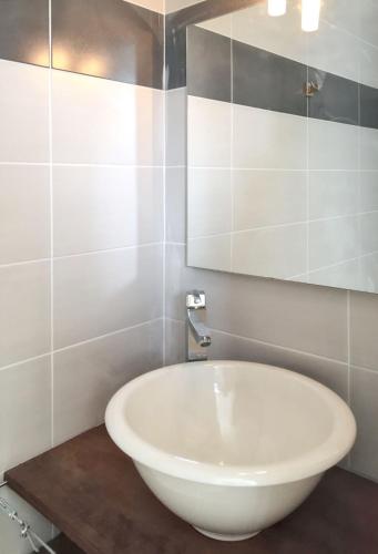 La salle de bains est pourvue d'une baignoire blanche et d'un miroir. dans l'établissement Maison charmante à Agde avec jardin et aire de jeux., à Agde