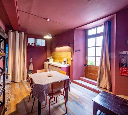 une salle à manger avec une table et une cuisine dans l'établissement Eau Berges - Chez Mamie, à Vicdessos