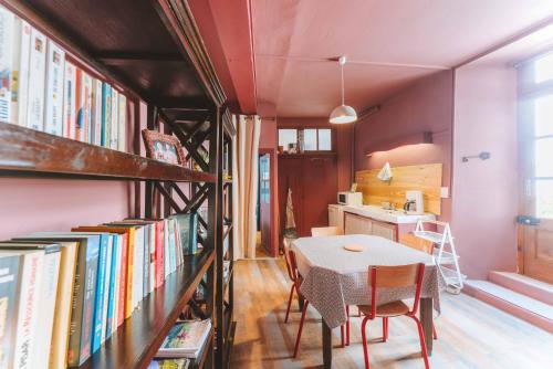 une cuisine et une salle à manger avec une table et des livres dans l'établissement Eau Berges - Chez Mamie, à Vicdessos