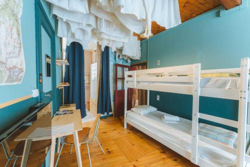 une chambre avec deux lits superposés et un bureau dans l'établissement Eau Berges - Chez Mamie, à Vicdessos