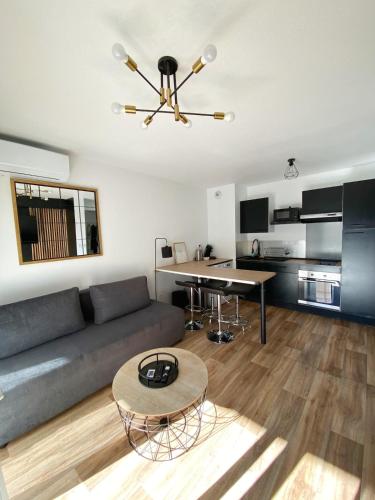 un salon avec un canapé et une table dans l'établissement Le Mayda - Parking Privé Gratuit, à Marseille