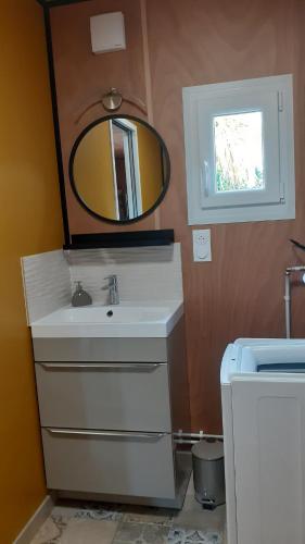 une salle de bain avec un lavabo et un miroir dans l'établissement le Clos des Golferies, chalet avec jacuzzi, à Les Mothes