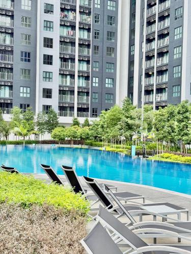 a swimming pool with lounge chairs in front of a building at Gamuda Cove,Splash Mania by Solace Place in Pulau Kempas