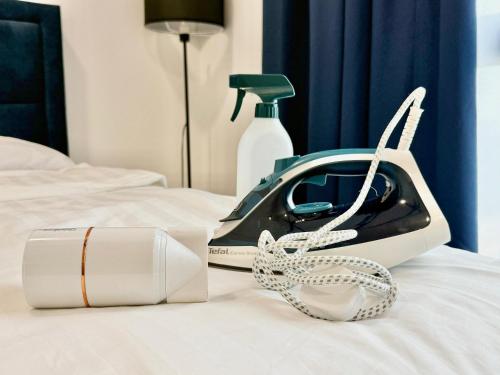 a hair dryer and a pair of shoes on a bed at Gamuda Cove,Splash Mania by Solace Place in Pulau Kempas