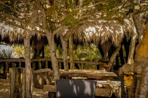 a table and a chair under a straw hut at Cinnabar Resort in Tangalle
