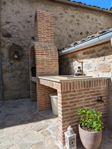 an outdoor kitchen with a sink and a brick wall at Passo del Mattino in Locati