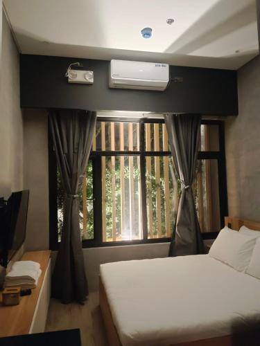 a bedroom with a bed and a window at Caldwell Boutique Hotel in Legazpi
