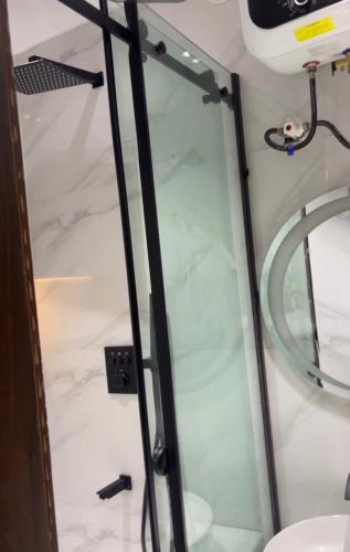 a shower with a glass door in a bathroom at Meenah luxury homes in Ikeja