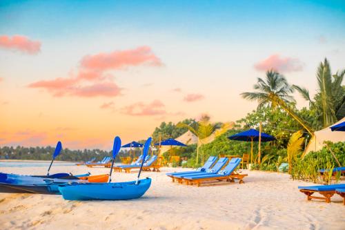 a group of beach chairs and umbrellas on a beach at The MAVERICK SURF AND DIVE BOUTIQUE HOTEL - Book 10 Nights and get 1 Free Night - Free Speed Boat Service - Kids Stay Free in Laamu