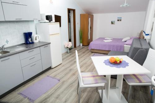 a kitchen with a table with a bowl of fruit on it at apartments VIGI - III in Povljana