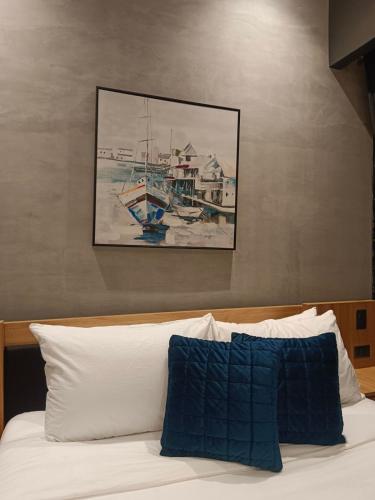 a bedroom with a bed with a painting on the wall at Caldwell Boutique Hotel in Legazpi