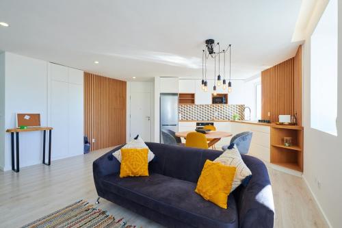 a living room with a blue couch and a kitchen at Apartment with Beach View - Ala-Arriba in Póvoa de Varzim
