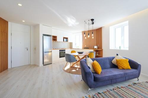 a living room with a blue couch and a table at Apartment with Beach View - Ala-Arriba in Póvoa de Varzim