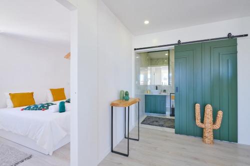 a bedroom with a green sliding door and a cactus at Apartment with Beach View - Ala-Arriba in Póvoa de Varzim