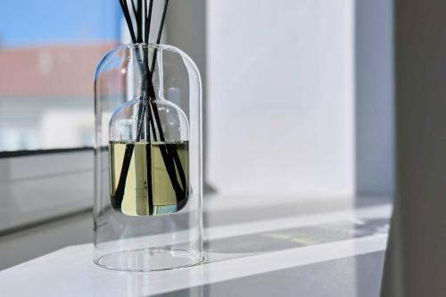 a glass vase with sticks in it on a table at Apartment with Beach View - Ala-Arriba in Póvoa de Varzim