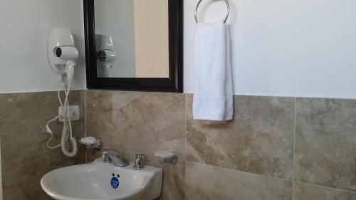 a bathroom with a sink and a mirror at Hostal Marlyn in San Andrés