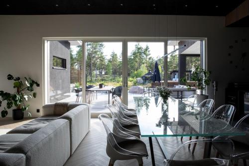 Una sala de estar con una mesa de cristal y sillas. en Forest Dream House, en Naantali