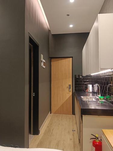 a kitchen with a wooden door and a sink at Caldwell Boutique Hotel in Legazpi