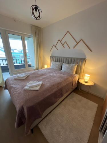 a bedroom with a large bed with a large window at Mountain Dream Bjelašnica in Bjelašnica