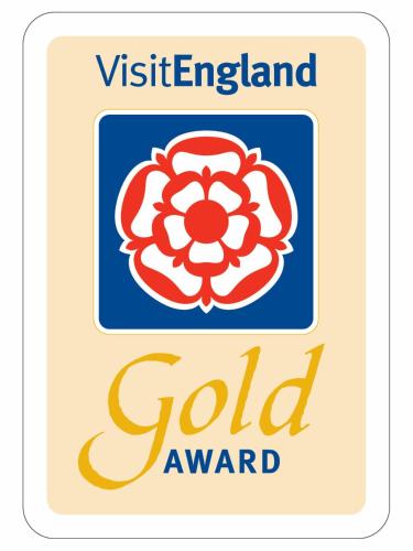 a sign for a gold award with a red flower at The Old Posthouse B&B in Caenby