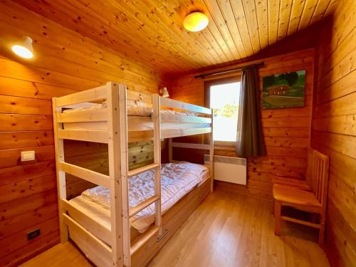 - une chambre avec des lits superposés dans une cabane en rondins dans l'établissement Chalet Les 3 Lueurs, authentique au pied de pistes, à Xonrupt-Longemer
