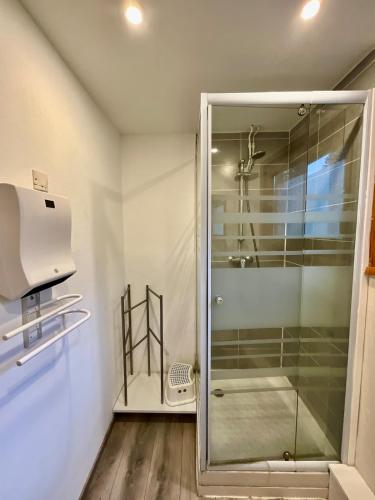une douche avec une porte vitrée dans une salle de bain dans l'établissement Chalet Les 3 Lueurs, authentique au pied de pistes, à Xonrupt-Longemer