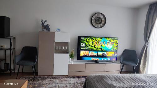 a living room with a television and two chairs at Schicke Ferien Wohnung mit tollem Ausblick in Schwarzwald. in Villingen-Schwenningen