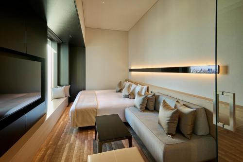 a hotel room with two beds and a couch at The Royal Park Hotel Iconic Tokyo Shiodome in Tokyo
