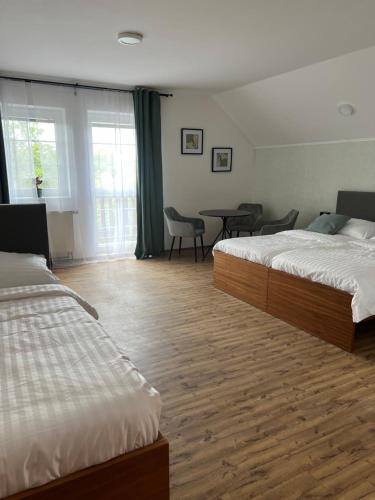 a hotel room with two beds and a table and chairs at Restaurace a penzion U svaté Barbory in Řehlovice