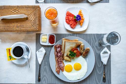 a plate of breakfast food with eggs bacon and toast at green slope villa glamping in Gitgit