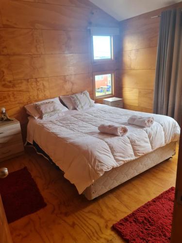 a bedroom with a bed with two towels on it at cabaña vista mágica in Castro