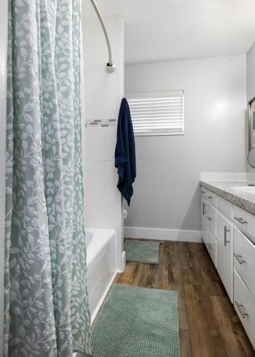 a bathroom with a shower curtain and a tub at Basin Staycation in Vernal