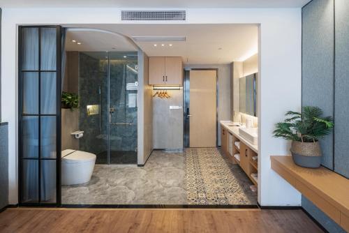 a bathroom with a shower and a toilet and a sink at ChongQing BackHome Riverview Hotel in Chongqing