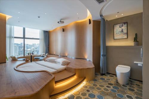 a bedroom with a bed in the middle of the room at ChongQing BackHome Riverview Hotel in Chongqing