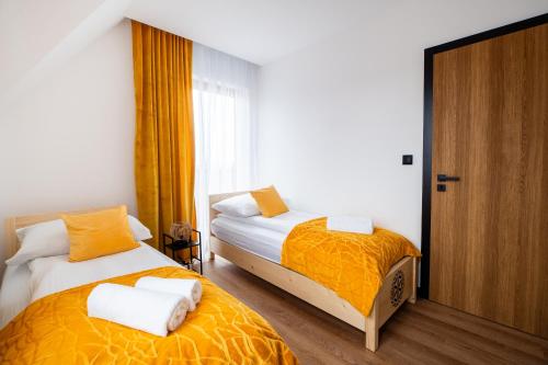 a bedroom with two beds and a window at Apartamenty Podtatrzański in Leśnica