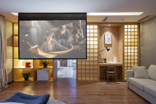 a living room with a movie projected on the wall at ChongQing BackHome Riverview Hotel in Chongqing
