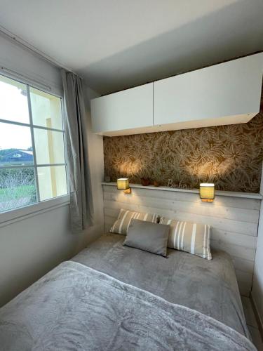 une petite chambre avec un lit et une fenêtre dans l'établissement Charmant logement Port Bourgenay, à Talmont-Saint-Hilaire