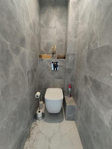 une salle de bain avec toilettes et un mur carrelé dans l'établissement L'Exclusif Paris Neuilly Levallois, à Levallois-Perret