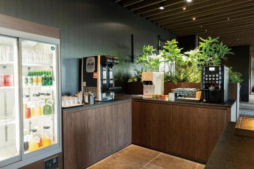 a coffee shop with a counter and a refrigerator at The Royal Park Hotel Iconic Tokyo Shiodome in Tokyo