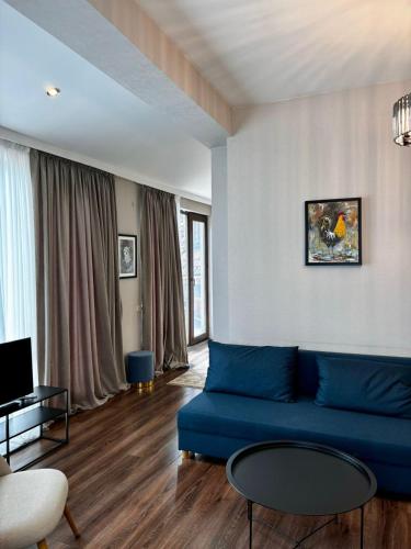 a living room with a blue couch and a table at Apartment 17 in Mtskheta