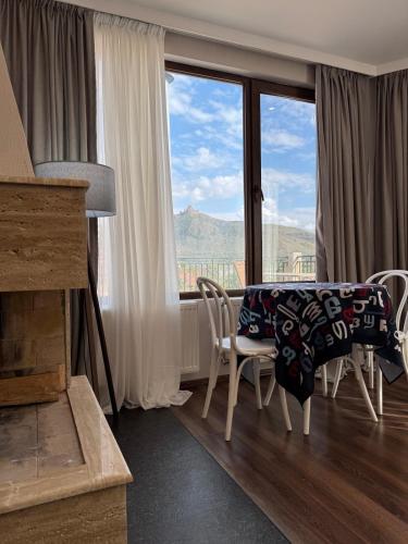 a living room with a table and chairs and a large window at Apartment 17 in Mtskheta